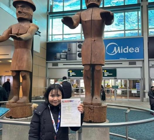 Khách hàng New Life Immigration cầm Work Permit tại sân bay Canada – chính thức bắt đầu hành trình làm việc và định cư theo diện tay nghề.